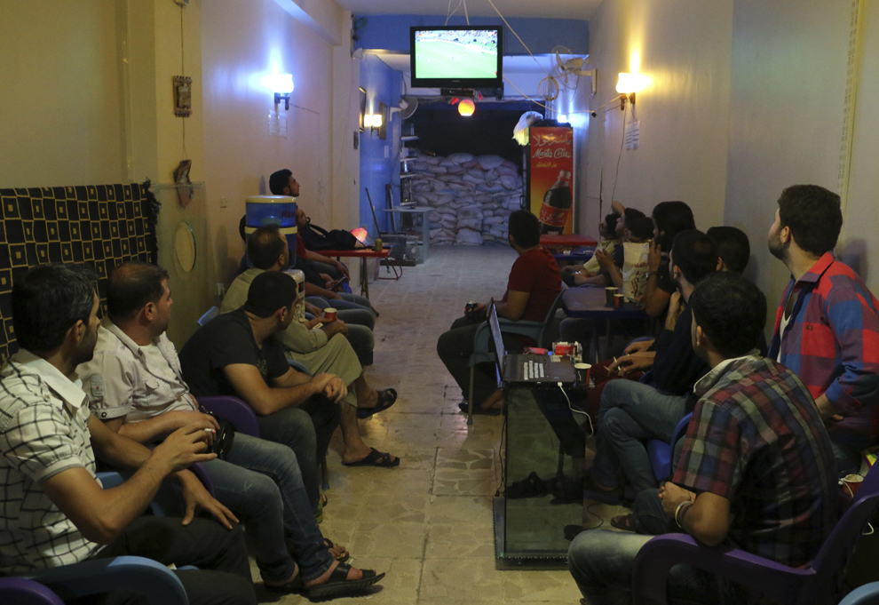 Sirieni urmăresc o transmisiune în direct din timpul finalei Cupei Mondiale la fotbal FIFA 2014, dintre Germania şi Argentina, în cartierul al – Firdous din oraşul Alepp, duminică, 13 iulie 2014.