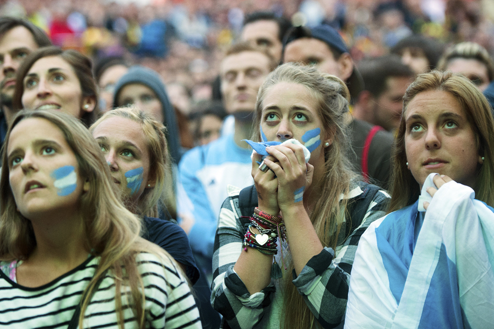 Argentinieni reactionează în timpul unei transmisiuni în direct din timpul finalei Cupei Mondiale la fotbal FIFA 2014, dintre Germania şi Argentina, în Berlin, Germania, duminică, 13 iulie 2014.