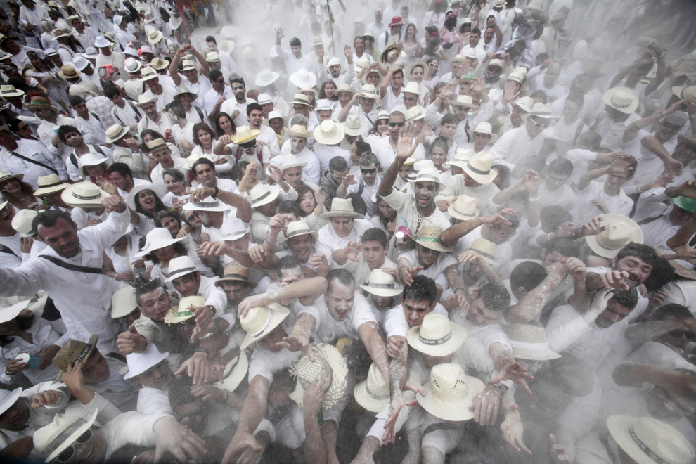 Mai mulţi participanţi aruncă cu pudră de talc, în timpul carnavalului “Los Indianos” (indienii), desfăşurat pe insula Las Palma din Spania, marţi, 11 februarie 2013. 