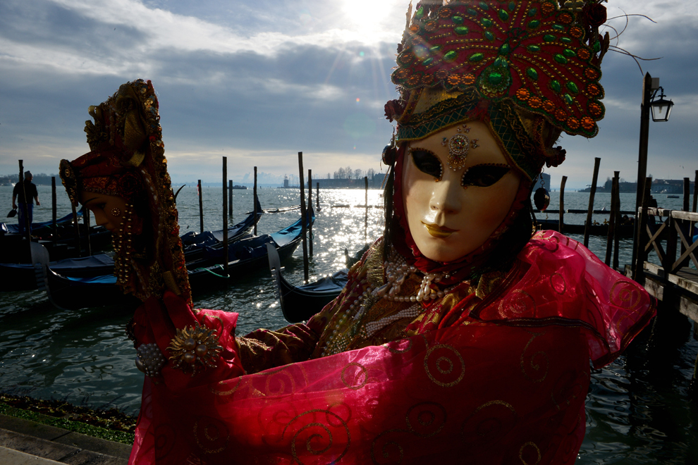 O femeie costumată pozează lângă gondole, în timpul carnavalului de la Veneţia, duminică, 3 februarie 2013. 