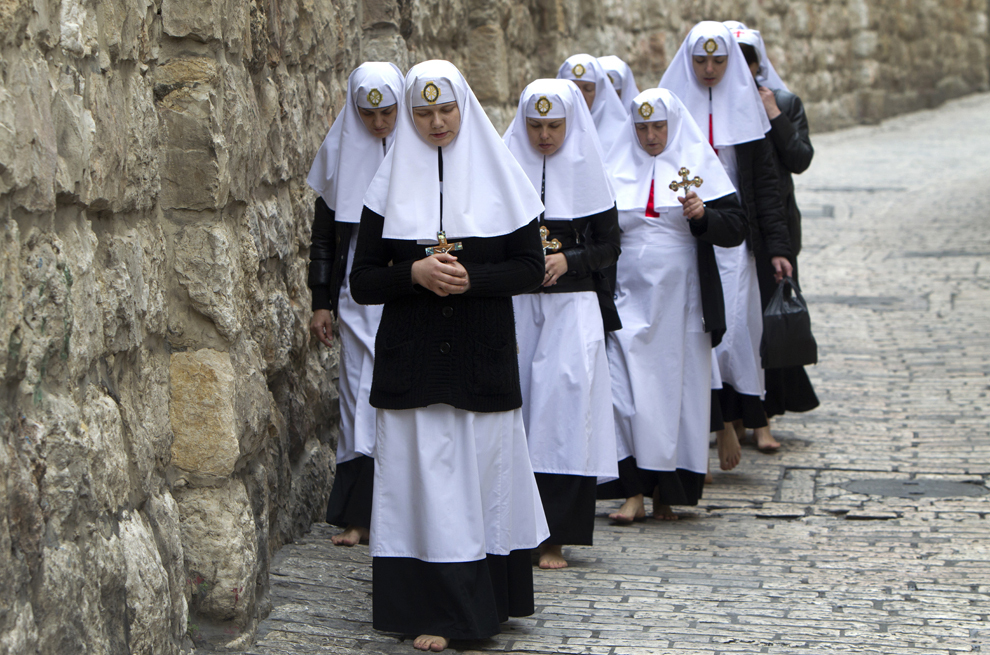 Un grup de călugăriţe creştin-ortodoxe refac, în picioarele goale, drumul parcurs de Iisus Christos spre locul crucificării, cunoscut ca ‘Via Dolorosa’, în oraşul vechi din Ierusalim, joi, 18 aprilie 2013. 