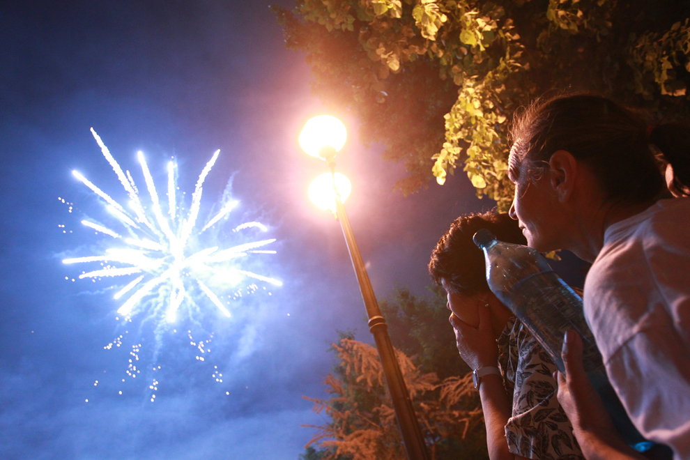 Participanţi la petrecerea dată de primaria sectorului 2, fac poze în timpul unui foc de artificii cu ocazia Zilei Internaţionale a Muncii, în Parcul Plumbuita din Bucureşti, marţi, 1 mai 2012. 