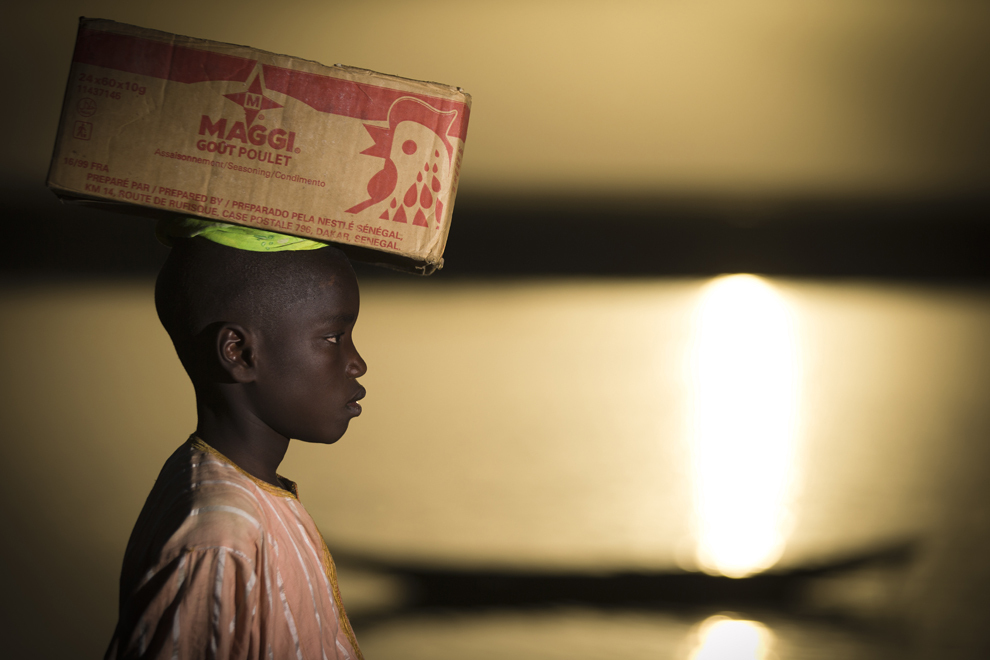 Un băiat cară o cutie cu alimente pe cap, lângă râul Niger, în Gao, Mali, miercuri, 3 aprilie 2013.  