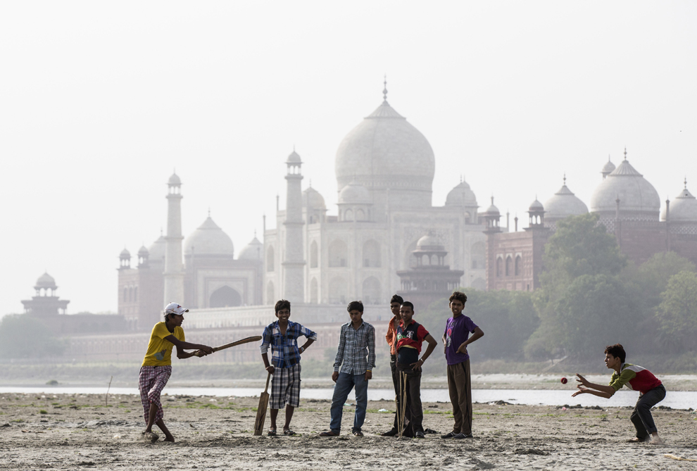 Copii indieni joacă cricket pe malul râului Yamuna, având Taj Mahalul în fundal, în Agra, India, marţi, 28 mai 2013. 