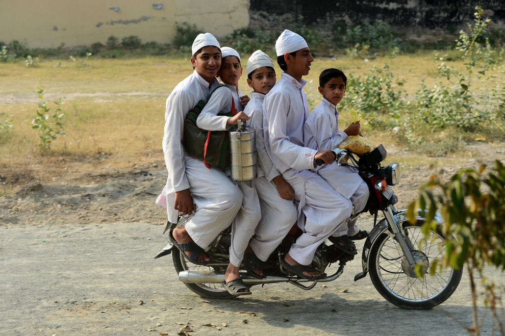 Patru fraţi pakistanezi alături de un prieten (S) se înghesuie pe o motocicletă în drumul de la şcoală spre casă, în Lahore, luni, 13 mai 2013. 