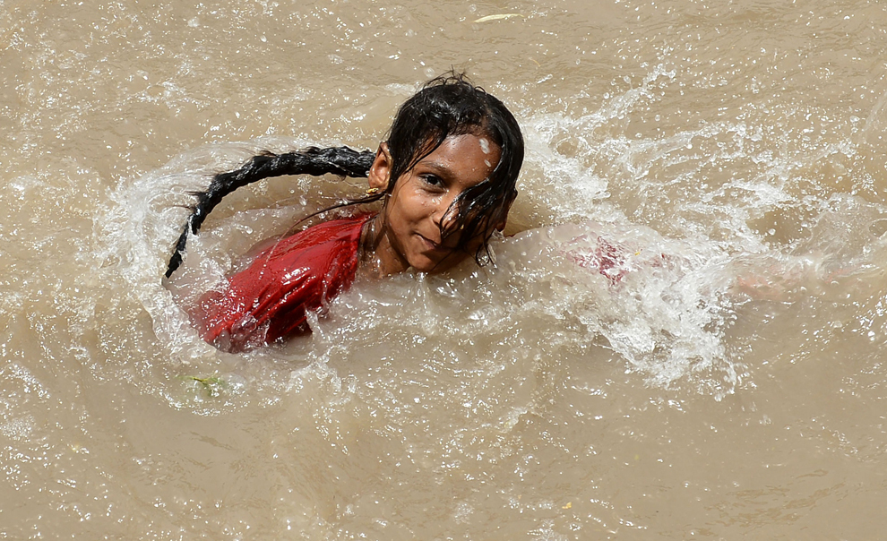 O tânără din Pakistan înoată într-un canal din Lahore, într-o zi toridă, duminică, 26 mai 2013. 