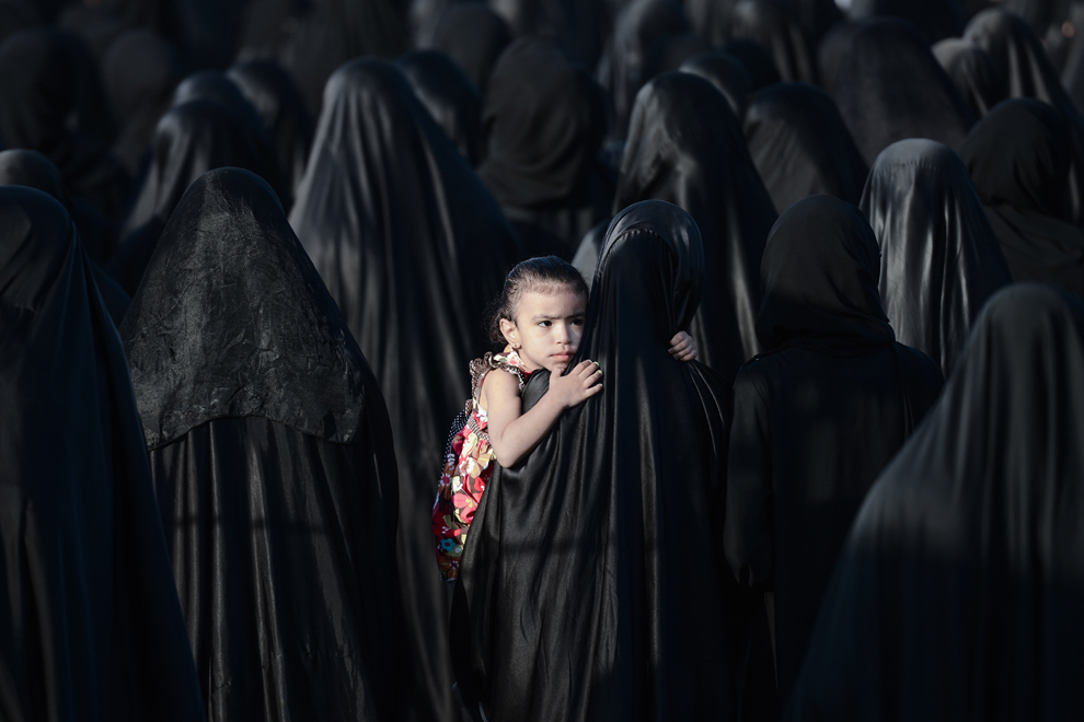 O tânără din Bahrain este purtată de mama ei în timpul funeraliilor lui Sayed Omran Hameed, în satul Karzakkan, la sud de Manama, marţi, 28 mai 2013. 