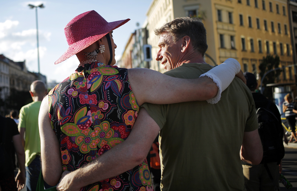 Doi bărbaţi merg ţinându-se în braţe, în timpul paradei alternative CSD (Cristopher Street Day Parade) prin cartierul Kreuzberg din Berlin, sâmbătă, 22 iunie 2013. 