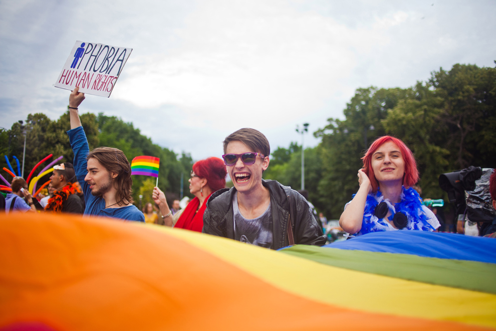 Persoane desfăşoara steagul LGBT, în timpul Marşului Diversităţii organizat de Asociaţia Accept cu ocazia celei de-a zecea ediţii a GayFest, în Bucureşti, sâmbătă, 8 iunie 2013. 