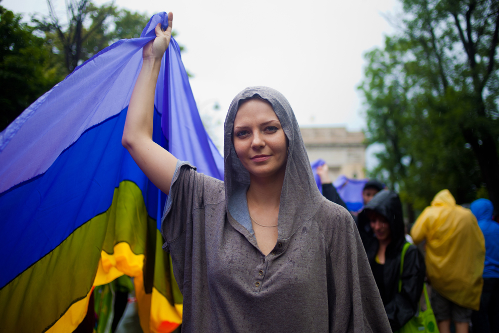 Persoane desfăşoara steagul LGBT, în timpul Marşului Diversităţii organizat de Asociaţia Accept cu ocazia celei de-a zecea ediţii a GayFest, în Bucureşti, sâmbătă, 8 iunie 2013. 