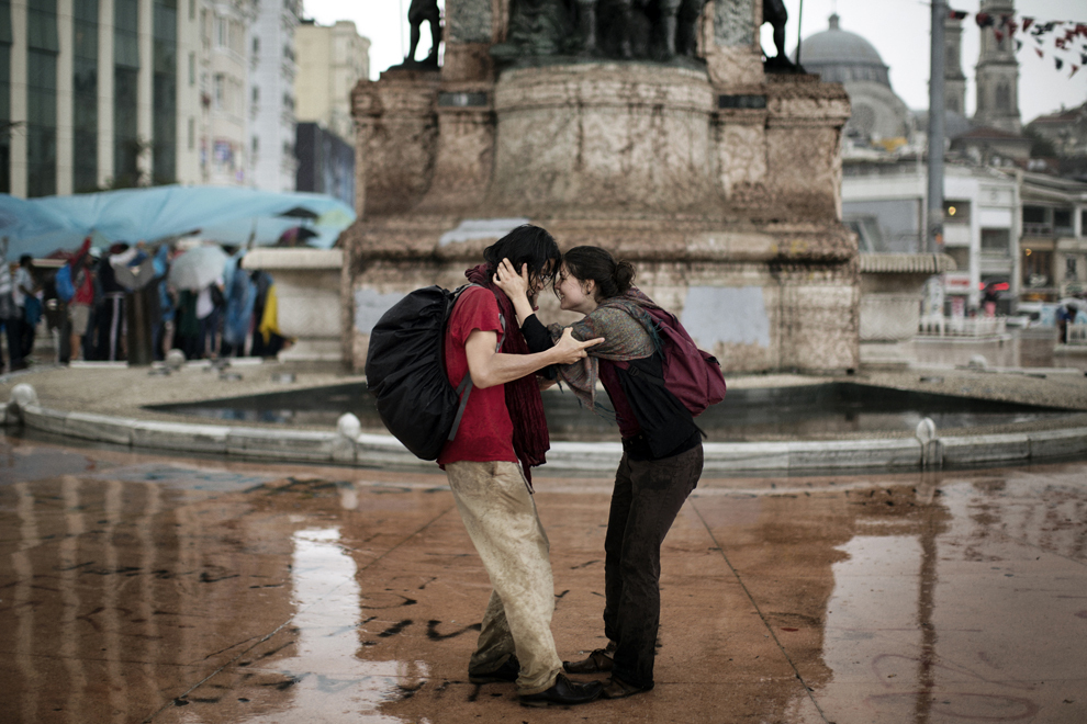 Un cuplu dansează în ploaie pe muzica unui pianist, în Piaţa Taksim din Istanbul, vineri, 14 iunie 2013. 