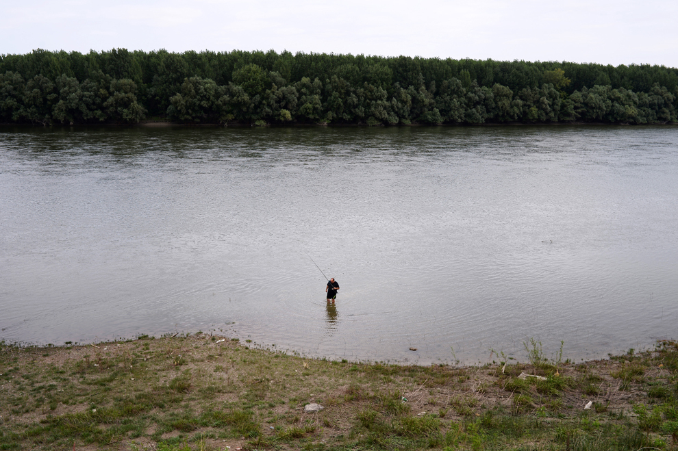 Un bărbat pescuieşte în fluviul Dunărea, în apropierea oraşului Kozloduy, Bulgaria, duminică, 21 iulie 2013. 
