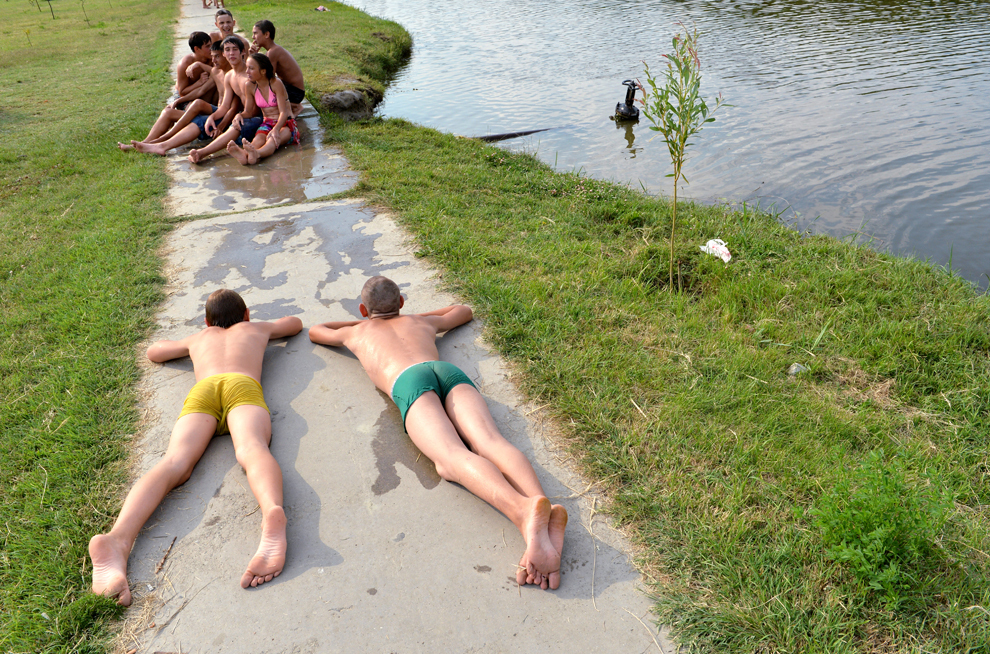 Mai mulţi copii fac plaja după ce au înotat într-unul din braţele Dunării, în oraşul ucrainean Izmail, în regiunea Odessa, miercuri, 10 iulie 2013. 
