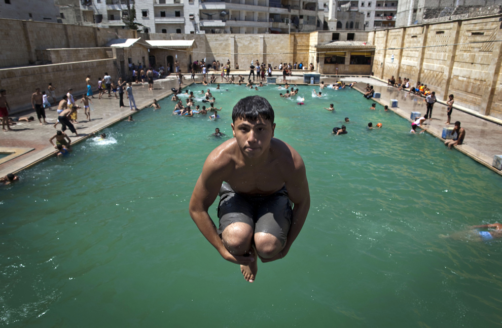 Un tânăr sirian sare într-o piscină din oraşul Aleppo, în nordul Siriei, vineri, 12 iulie 2013. 