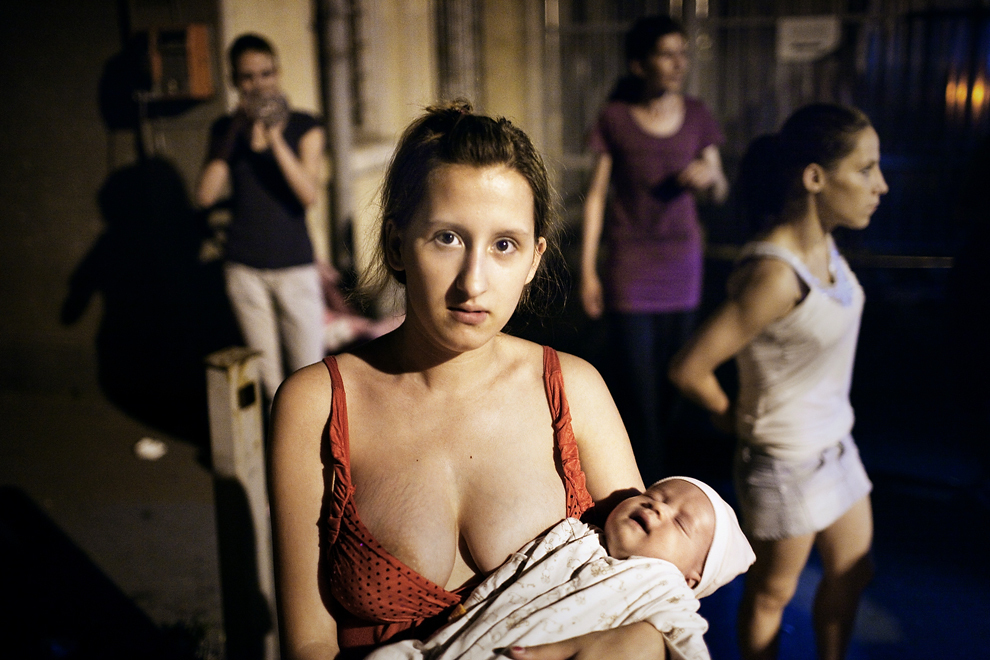 Larisa, mama unui nou-născut, îşi aşteaptă rândul pentru testele de depistare a bolilor cu transmitere sexuală, alături de Stela, pe o stradă din Bucureşti, joi, 23 iunie 2011. 