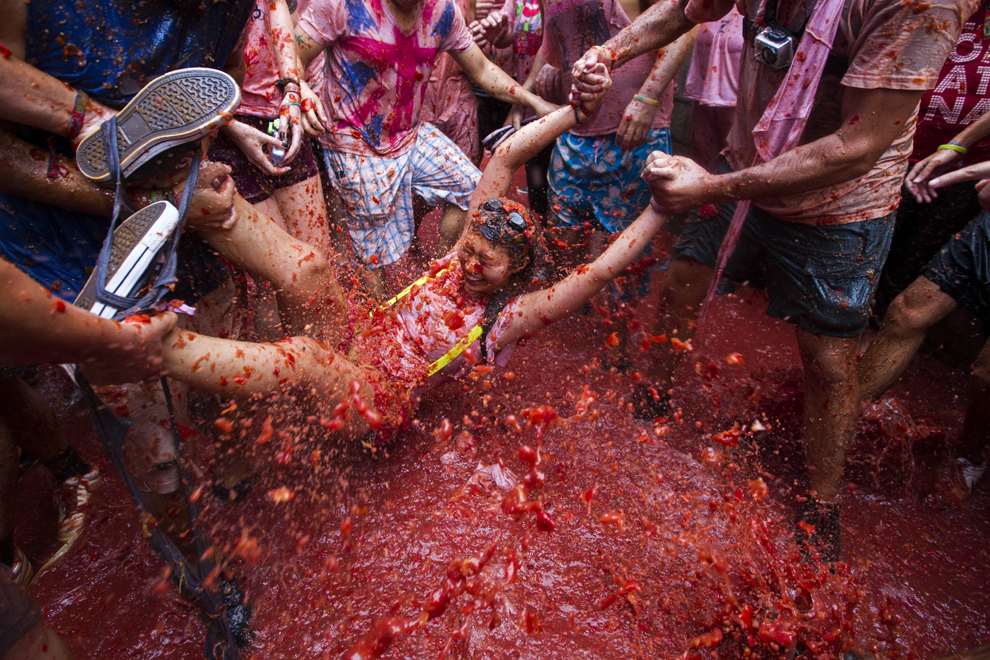 O participantă la festivalul anual "Tomatina" este aruncată în suc de roşii, în Bunol, lângă Valencia, miercuri, 28 august 2013. 
