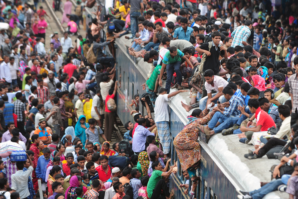 Mai multe persoane se urcă în şi pe un tren pentru a ajunge în satele în care locuiesc înaintea sărbătorii musulmane Eid al-Fitr, în Dhaka, Bangladesh, joi, 8 august 2013.  