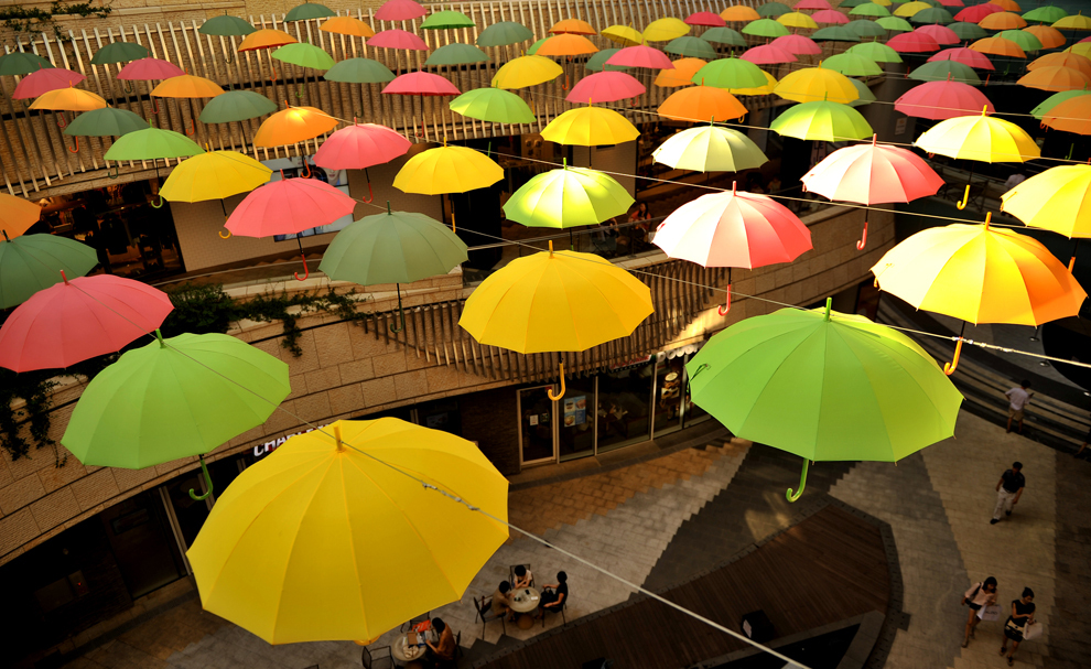 Oamenii merg printr-un mall unde umbrele sunt afişate, în Seul, Coreea de Sud, luni, 26 august 2013.  