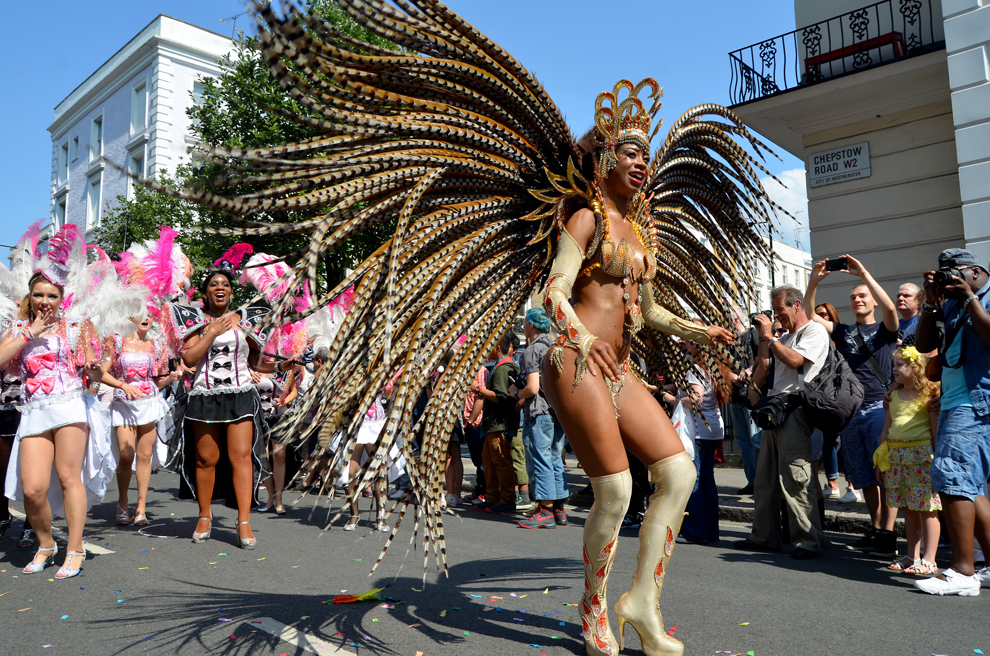 Persoane participă la carnavalul de la Notting Hill, în Londra, luni, 26 august 2013. Începând din 1964, comunităţile afro-caraibiene şi-au sărbătorit cultura şi tradiţiile printr-un festival de două zile, cu dans, muzică live şi mâncăruri specifice. 