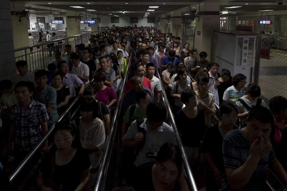 Navetişti aşteaptă să intre într-o staţie de metrou, în timpul orei de vârf, în Beijing, miercuri, 19 iunie 2013. 