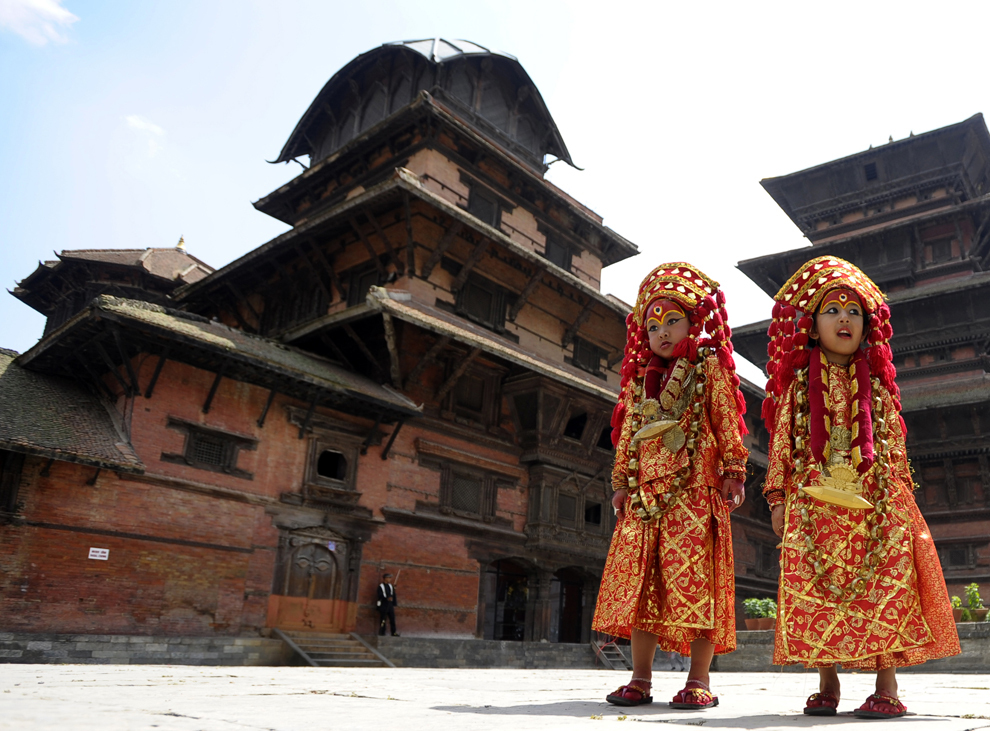 Două fetiţe nepaleze îmbrăcate în costumul zeiţei Kumari, pozează în timpul ritualurilor Kumari Puja la Hanuman Dhoka, în piaţa Durbar din Katmandu, marţi, 17 septembrie 2013.