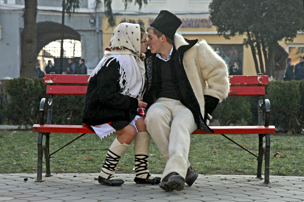 Doi tineri îmbrăcaţi în port popular maramureşean se sărută pe o bancă din Sighetu Marmaţiei, judeţul Maramureş, sâmbătă,  27 decembrie 2008.