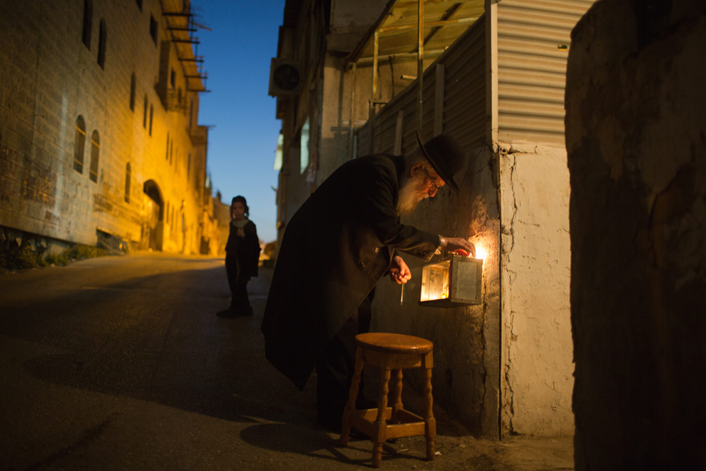 Un evreu ultra-ortodox aprinde lumânări în a şasea noapte a sărbătorii evreieşti Hanuka, într-un cartier religios din Ierusalim, luni, 2 decembrie 2013.