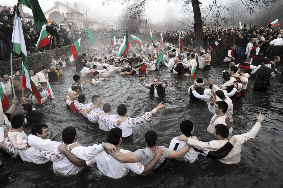 Mai mulţi bărbaţi dansează un dans tradiţional în apele reci ale râului Tundzha, în oraşul  Kalofer, Bulgaria, cu ocazia sărbătorii de Bobotează, luni, 6 ianuarie 2014.