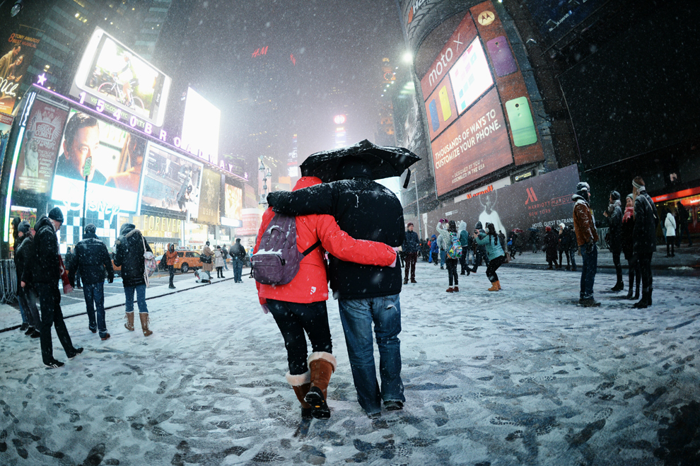 Vizitatorii se bucură de zăpada de pe Broadway, joi, 2 ianuarie 2014, la Times Square din New York.