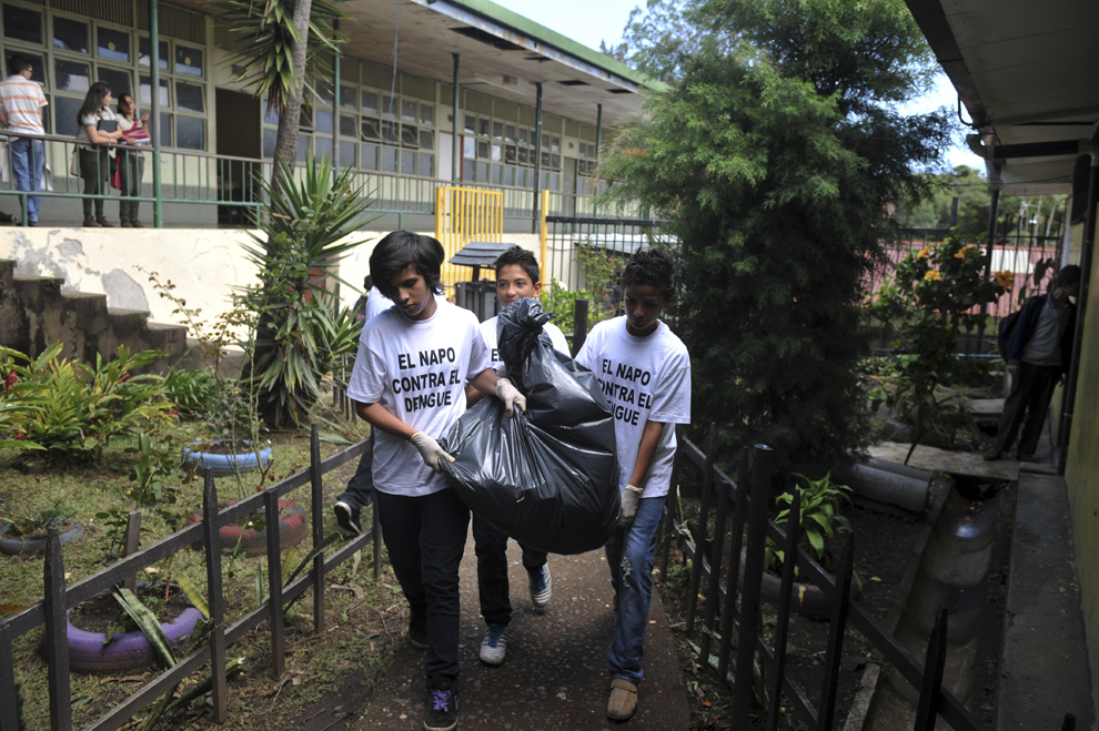 Un grup de elevi de la şcoala gimnazială Napoleon Quesada, curaţă curtea şcolii pentru a elimina posibilele zone de înmulţire a ţânţarului Aedes Agypti (vector pentru febra dengue), în San Jose, Costa Rica, luni, 19 august 2013. 