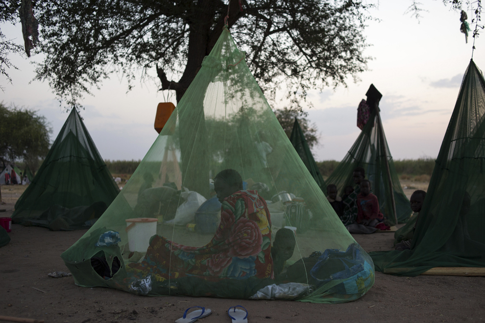 O femeie stă sub o plasă de ţânţari în apropiere de zona pentru refugiaţi White Nile, în Minkamen, Sudanul de Sud, sâmbătă, 11 ianuarie 2014.