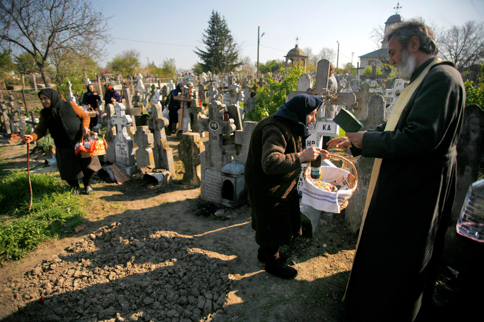 Un preot ortodox sfinţeşte coliva, în cimitirul satului Orbeasca de Jos (judeţul Teleorman), în Joia Mare din Săptămâna Patimilor, 16 aprilie 2009.