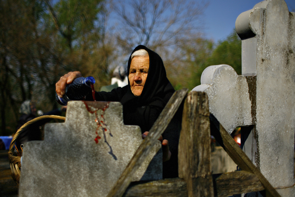 O femeie varsă vin pe piatra unui mormânt, în localitatea Orbeasca de Jos din judeţul Teleorman, în Joia Mare din Săptămâna Patimilor, 16 aprilie 2009.