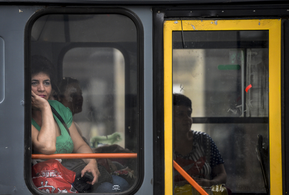 O femeie, aflată într-un mijloc de transport în comun, urmăreşte de la fereastră spectacolul "The Red Heart" al companiei Mademoiselle Paillette, în prima zi a B-FIT in the Street! - Festivalul Internaţional de Teatru de Stradă Bucureşti, în Piaţa Universităţii, joi, 29 mai 2014.