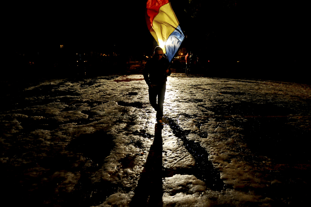 Un bărbat flutură un steag în timpul unui protest organizat de Liga Suporterilor Sibieni, în Piaţa Mare din Sibiu, sâmbătă, 4 februarie 2012.