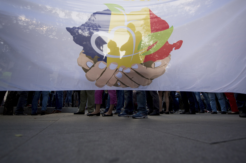 Oameni ţin un steag, în timpul unui protest faţă de exploatarea de la Roşia Montană, în Piaţa Universităţii din Bucureşti, duminică, 22 septembrie 2013.