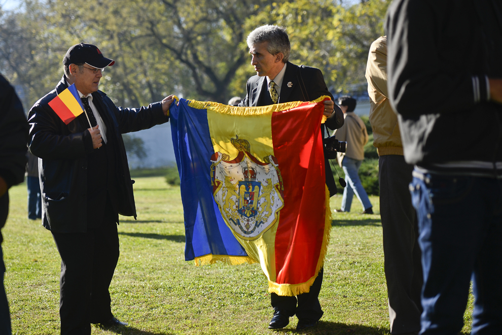 Doi bărbaţi desfăşoară un steag al României, având suprapus blazonul Casei Regale a României, în curtea Palatului Elisabeta, cu ocazia zilei de naştere şi a onomasticii Regelui organizându-se Ziua Porţilor Deschise la Palatul Elisabeta, în Bucureşti, vineri, 8 noiembrie 2013.
