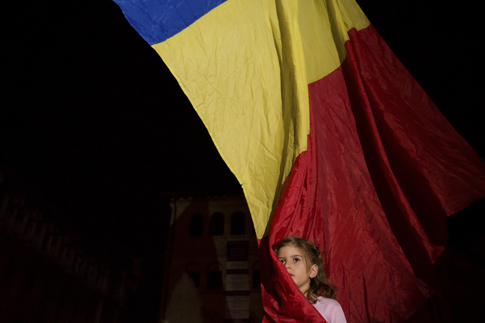 Erzsebet Maya, 6 ani, se înfăşoară în drapelul României, în timpul unui protest faţă de proiectul minier de la Roşia Montană şi faţă de explorarea gazelor de şist, în Bucureşti, luni, 9 septembrie 2013.
