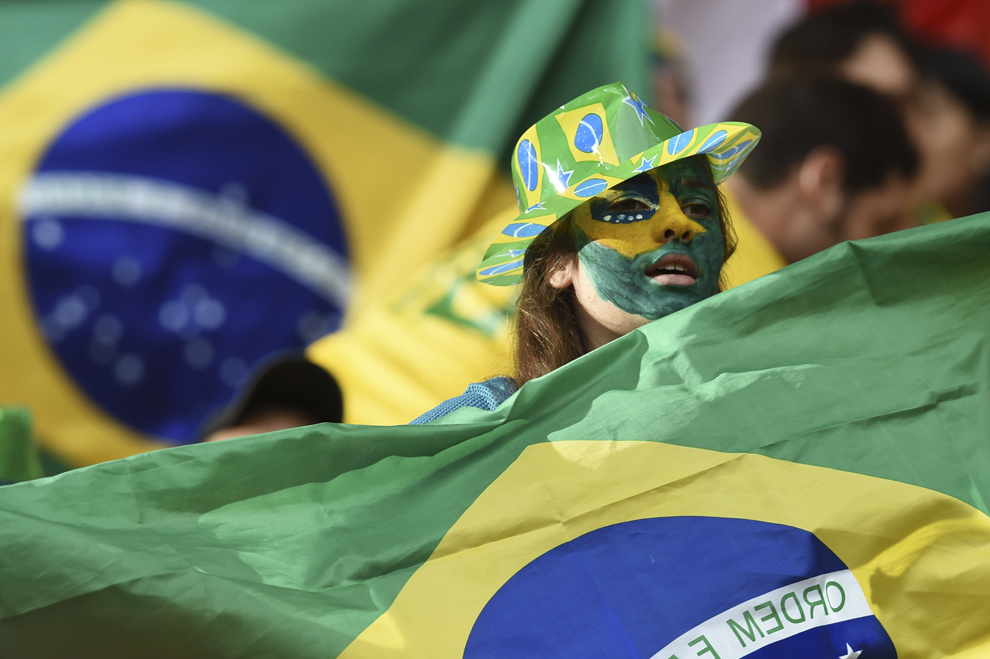Un suporter brazilian îşi încurajează echipa înaintea începerii meciului dintre Camerun si Brazilia, pe stadionul Mane Garrincha din Brasilia, 23 iunie 2014.