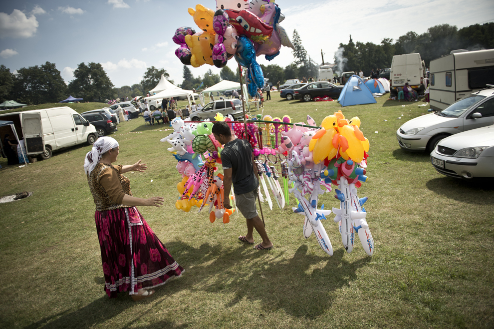 Un rom de naţionalitate română vinde baloane şi jucării gonflabile în timpul reuniunii anuale a romilor cu ocazia sărbătorii Naşterii Maicii Domnului, în Costeşti, Vâlcea, luni, 8 septembrie 2014.