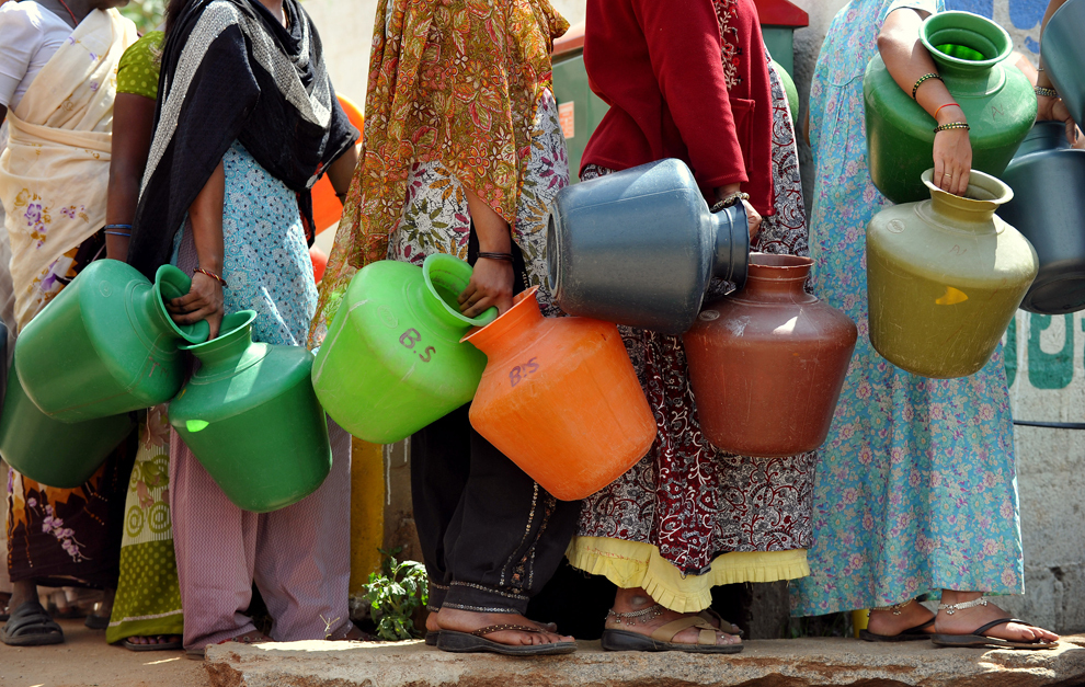 Mai multe femei dintr-un district afectat de lipsa apei potabile aşteaptă ţinând în mână vase din plastic, la o cişmea din Bangalore, luni, 8 octombrie 2012. 