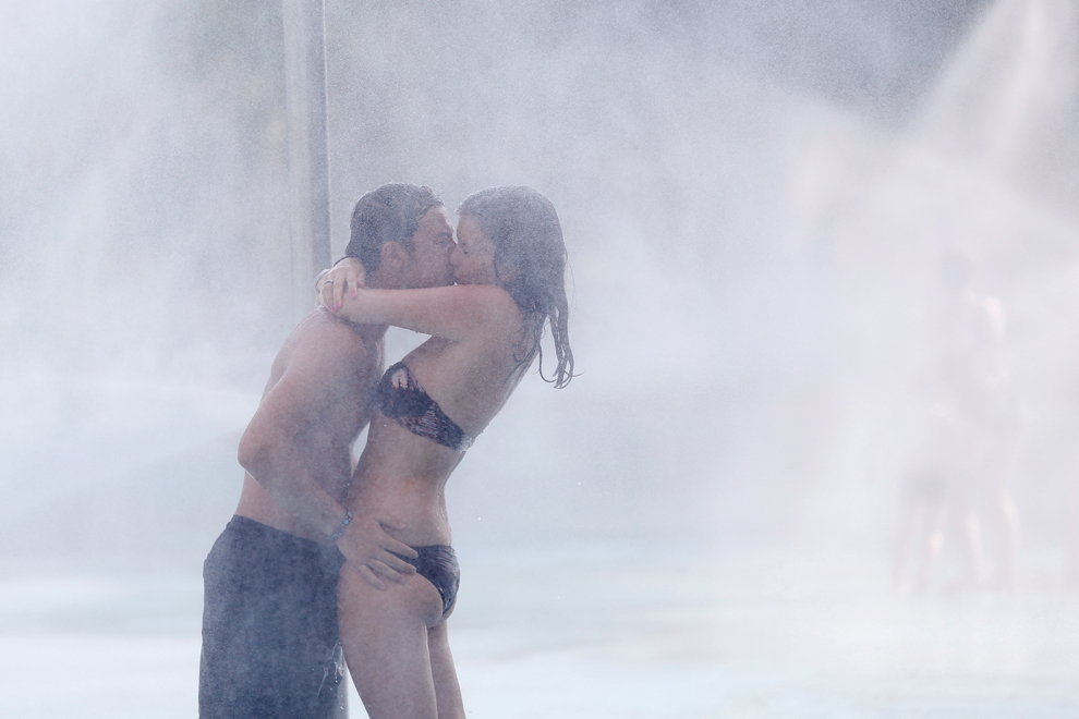Doi tineri se sărută sub apa unei fântâni dintr-un parc din Nisa, sud-estul Franţei, sâmbătă, 20 iulie 2013. 