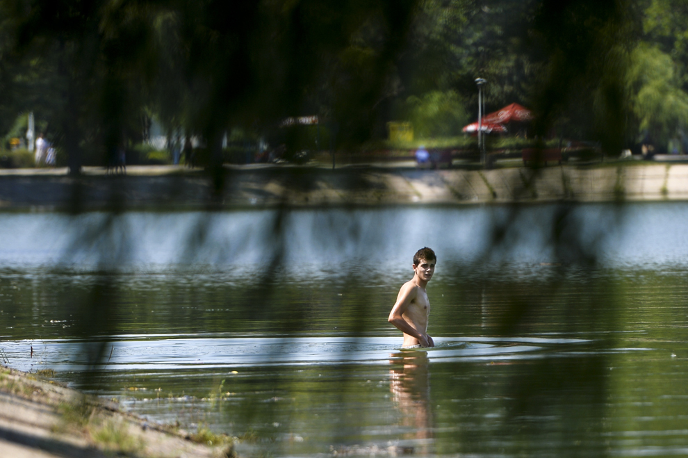 Un tânăr face baie în apele râului Colentina, în Bucureşti, luni, 29 iulie 2013. 