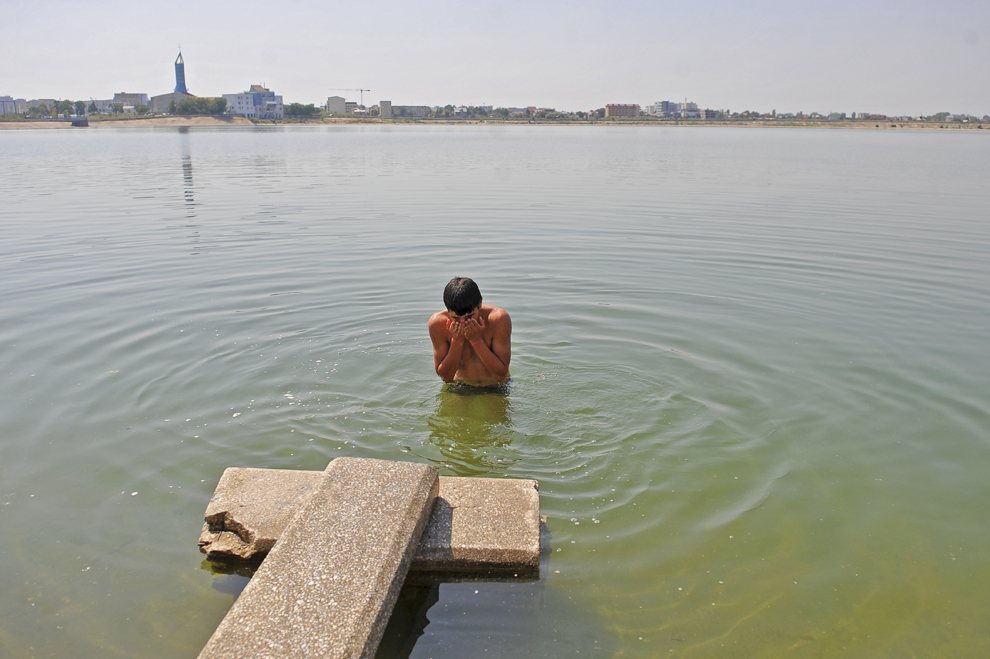 Un tânăr se scaldă în lacul Ciurel din Bucureşti, miercuri, 24 august 2011.
