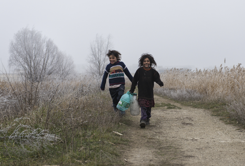 Surorile Tudora Nedelcu, zece ani, şi Vasilica Nedelcu, şapte ani, se duc să ia apă de la unul din cele două izvoare din care s-a născut Delta Văcăreşti, în Groapa Văcăreşti, joi, 19 decembrie 2013.