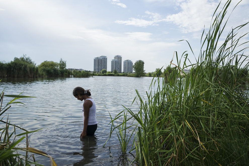 Mariana, 12 ani, se răcoreşte într-unul din ochiurile de apă din Delta Văcăreşti, în Groapa Văcăreşti, vineri, 14 iunie 2013.