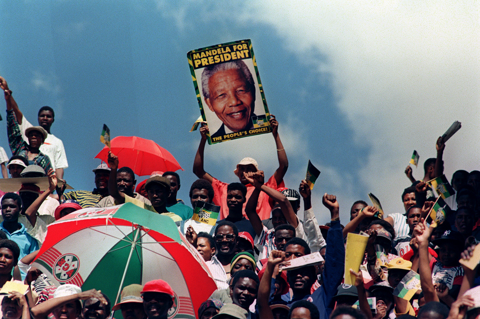 Suporteri ai Congresului National African (CNA) ascultă discursul preşedintelui CNA, Nelson Mandela, în timpul unui miting electoral, înaintea alegerilor generale care urmează să aibă loc pe 27 aprilie, în Mmabatho, marţi, 15 martie 1994. 