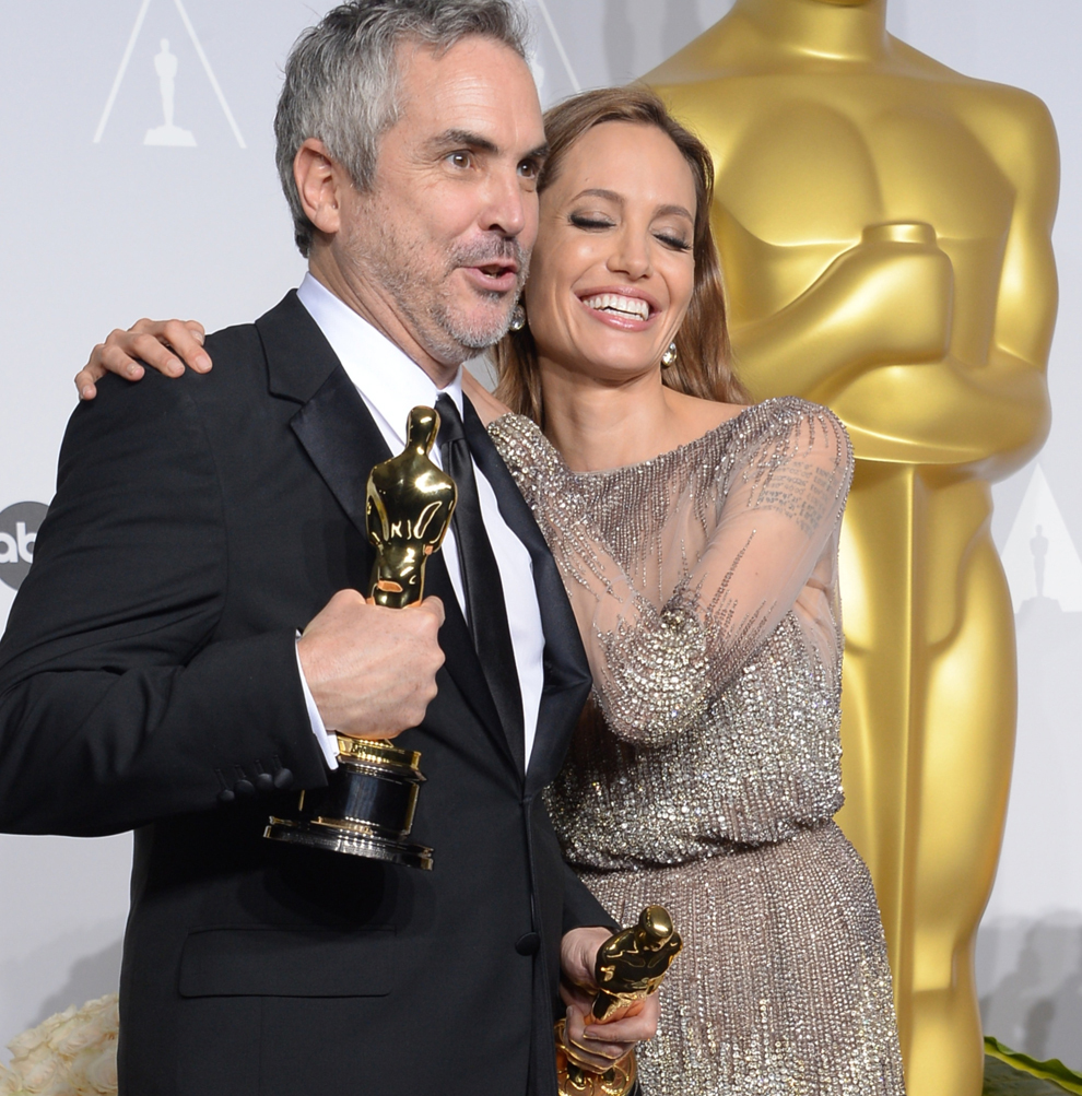 Regizorul Alfonso Cuarón (S), câştigător al categoriei Cel mai Bun Regizor pentru regia filmului Gravity şi actriţa Angelina Jolie pozează  în timpul celei de-a  86-a ceremonii de decernare a Oscarurilor, în Hollywood, California.