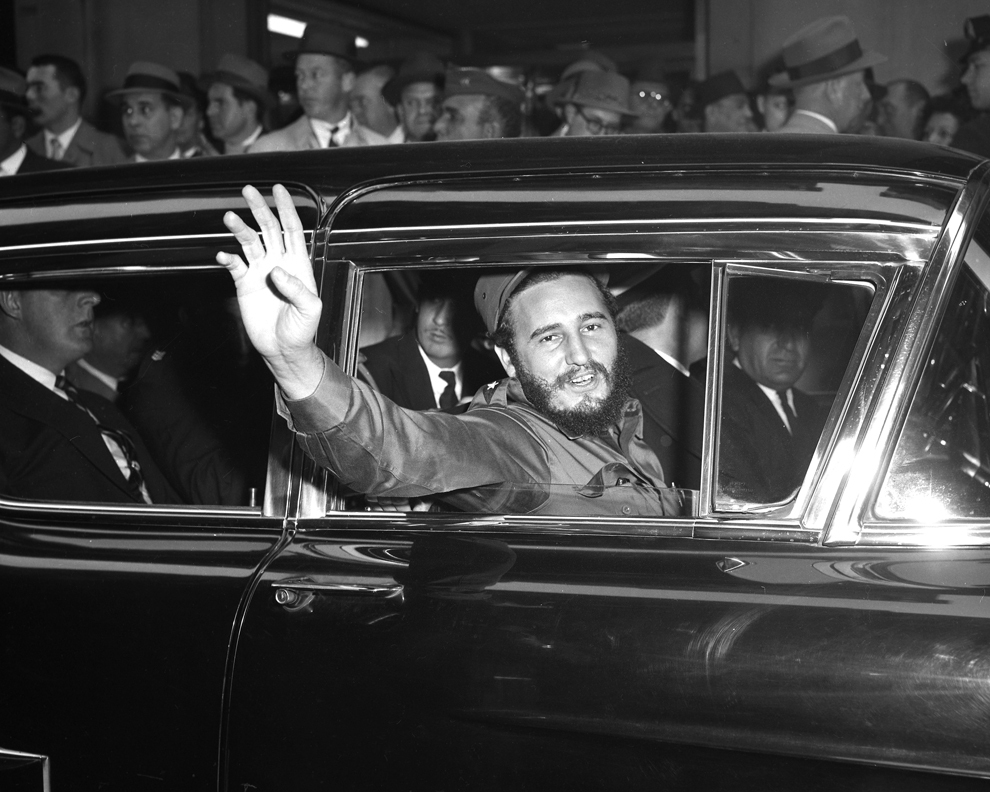 Fidel Castro face cu mâna dintr-o maşina în apropiere de Hotelul Statler, în timpul unei vizite în New York.