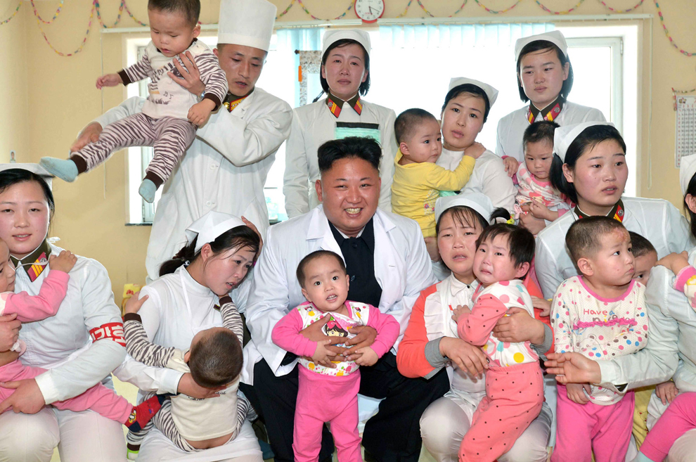 Liderul nord-coreean Kim Jong-un (C) este înconjurat de copii în timpul unei vizite la secţia de pediatrie  a spitalului Taesongsan din Phenian, într-o imagine nedatată,  furnizată  luni, 19 mai 2014.   